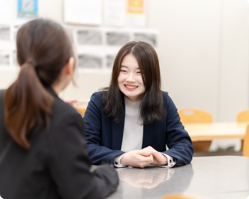 白衣風のユニフォームを着た男女2人が屋外で並んで微笑んでいる